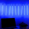 Blue LED string lights hanging above a laptop and a decorative item. Produktbild-Vorschau