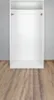 An empty white wardrobe interior with a clothes rail, against a light gray wall and a wooden floor. Náhľad obrázku produktu