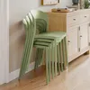A stack of green chairs next to a wooden cabinet. Náhled obrázku produktu
