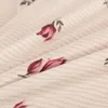 A close-up view of a fabric with a floral pattern. Produktbild-Vorschau