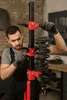 A mechanic is using a spring compressor tool to work on a car's suspension. Anteprima dell’immagine prodotto