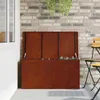 An outdoor storage box with its lid open, placed on a patio next to a brick wall and a chair. Voir les images du produit