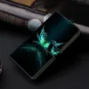 A black wallet-style phone case with a turquoise and green butterfly design is displayed on a dark surface, with a watch partially visible in the background. Produktbild-Vorschau