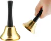 A hand holding a golden bell with a black handle. Náhled obrázku produktu