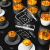 A collection of crystal glasses with gold interiors and black exteriors, arranged on a black surface, with a trophy in the center. Náhled obrázku produktu