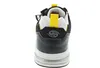 The back view of a black and white sneaker with yellow accents. Voir les images du produit