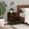 A bedside table with a drawer and shelf next to a bed, with a plant and decorative items on top. Podgląd zdjęcia produktu