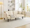 A beige sofa is shown in a well-lit living room with a bookshelf in the background and a window on the right. Voir les images du produit