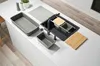 A collection of kitchen sink accessories laid out on a white countertop. Voir les images du produit