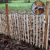 A wooden picket fence with wire reinforcement in an outdoor setting with fallen leaves on the ground. Produktbild-Vorschau