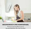 A woman is cooking in a modern kitchen, with a range hood visible above her. Produktbild-Vorschau