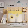 A child's loft bed with a slide and tent-like curtains, decorated with wall art and a rug with toys. Produktbild-Vorschau