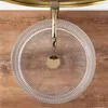 A top-down view of a transparent glass sink with a gold faucet, set against a wooden background. Anteprima dell’immagine prodotto