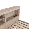 A close-up view of a wooden bed frame with built-in storage and electrical outlets. Produktbild-Vorschau