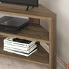 A close-up view of a corner TV stand with a game console and books on its shelves. Podgląd zdjęcia produktu