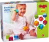 A baby playing with HABA Entdeckersteine (discovery stones) on a bed. Podgląd zdjęcia produktu