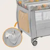A close-up view of a side pocket on a travel crib, with baby items inside. Produktbild-Vorschau