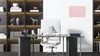 A modern office setting with a desk, chair, computer, and shelves filled with books and decorative items. Anteprima dell’immagine prodotto