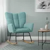 A teal rocking chair with wooden rockers is shown in a room with a light gray wall and a patterned rug. Produktbild-Vorschau