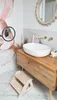 A child's bathroom with a large bunny decal on the wall, a wooden vanity with a vessel sink, and a wooden step stool in front of it. Náhľad obrázku produktu