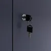 A close-up view of a lock and two keys on a dark gray surface. Produktbild-Vorschau