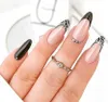 A close-up shot of a hand with manicured nails, showcasing different nail art designs and a ring. Náhľad obrázku produktu