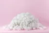 A pile of white fluffy material on a pink background. Produktbild-Vorschau