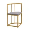 A gold metal corner chair with a gray seat, isolated on a white background. Voir les images du produit