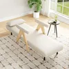 A cream-colored chaise lounge with wooden armrests is placed on a patterned rug in a well-lit room with a large window. Produktbild-Vorschau