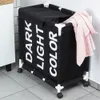 A laundry basket with three compartments and wheels is shown in a bathroom or laundry room setting. Náhled obrázku produktu