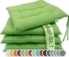 A stack of four green seat cushions with a promotional ribbon. Produktbild-Vorschau