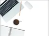 A flat lay of a laptop, coffee cup, pencil, mouse, and notebook on a white background. Produktbild-Vorschau