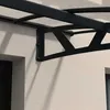 A close-up view of a black metal bracket supporting a clear canopy structure attached to a textured wall. Podgląd zdjęcia produktu