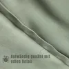A close-up view of green fabric with a seam and text overlay. Produktbild-Vorschau