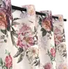 A close-up view of a floral patterned curtain with grommets. Produktbild-Vorschau