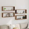 Four wooden wall shelves are mounted on a white wall above a sofa. The shelves are decorated with various items. Náhled obrázku produktu