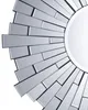 A close-up, angled view of a sunburst-style mirror with a silver frame and mirrored glass. Náhľad obrázku produktu