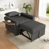 A dark gray sofa bed is shown in a living room setting, with a small wooden side table holding a cup of coffee. Podgląd zdjęcia produktu