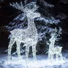 Two illuminated reindeer figures stand in the snow at night, with a snow-covered tree in the background. Anteprima dell’immagine prodotto