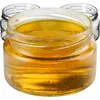 Three glass jars filled with honey, with the front jar in focus. Podgląd zdjęcia produktu