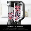 A blender jar filled with frozen berries, with a split view showing the contents and the blender base. Voir les images du produit