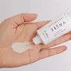 A hand is squeezing a tube of cream onto the palm of another hand. Podgląd zdjęcia produktu
