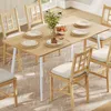 A dining table set up for a meal with chairs around it, in a brightly lit room. Produktbild-Vorschau