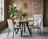 A dining table set in a room with a brick wall and a large window. Produktbild-Vorschau