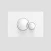 A close-up, studio shot of a white toilet flush plate with two circular buttons. Produktbild-Vorschau