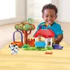 A young boy is playing with a Vtech Tut Tut Animo toy set on a table. Produktbild-Vorschau