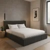 A bedroom scene with a bed, nightstand, and artwork. Náhled obrázku produktu