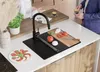A modern kitchen scene with a sink, faucet, cutting board with ingredients, and a plate of food. Produktbild-Vorschau
