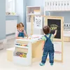 Two young children are actively engaged in creative activities at a wooden art easel and desk set in a brightly lit room. Produktbild-Vorschau