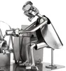 A metal figurine of a tattoo artist working on a tattoo machine. Produktbild-Vorschau